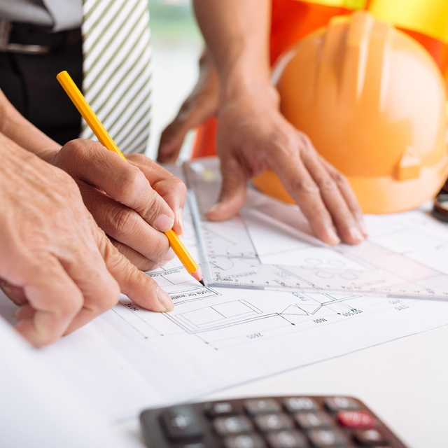 Architect drawing with set square and visible calculator
